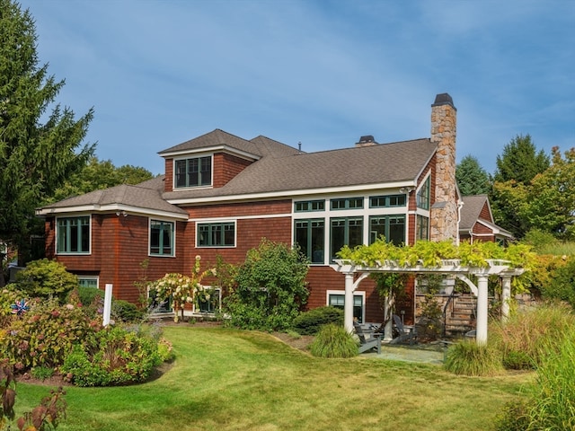 rear view of property featuring a lawn and a pergola