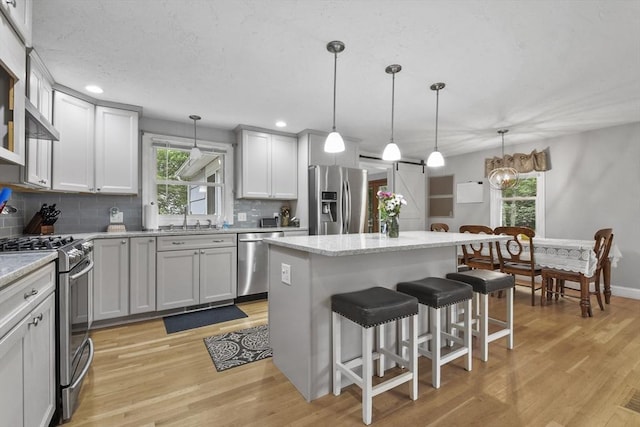 74 S Douglas St, Rockland, MA 02370 - kitchen with stainless steel appliances, tasteful backsplash, a breakfast bar area, light wood-style flooring, and recessed lighting