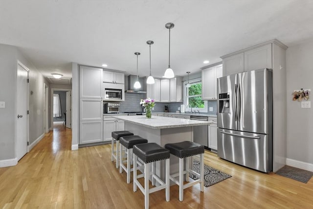 74 S Douglas St, Rockland, MA 02370 - kitchen with appliances with stainless steel finishes, wall chimney range hood, light wood-type flooring, a kitchen island, and recessed lighting