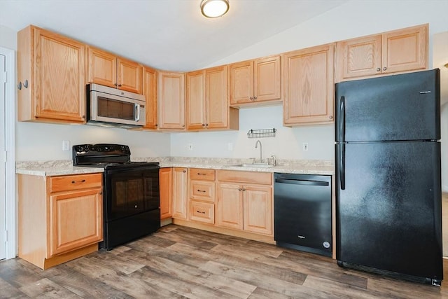 kitchen featuring lofted ceiling, sink, hardwood / wood-style floors, black appliances, and light brown cabinetry