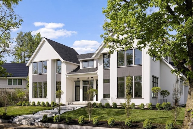 rear view of property featuring stucco siding and a lawn