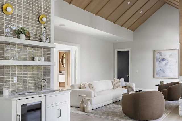 living area with wood finished floors, wet bar, high vaulted ceiling, recessed lighting, and beverage cooler