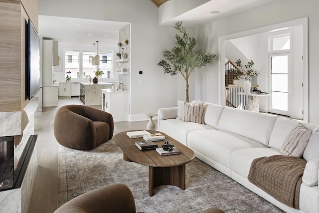 living area with light wood-style flooring and stairs