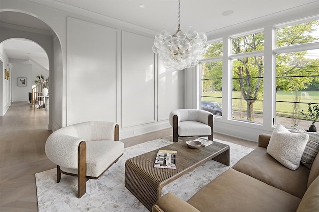 interior space with a wealth of natural light, a chandelier, and arched walkways