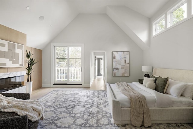 bedroom with baseboards and high vaulted ceiling