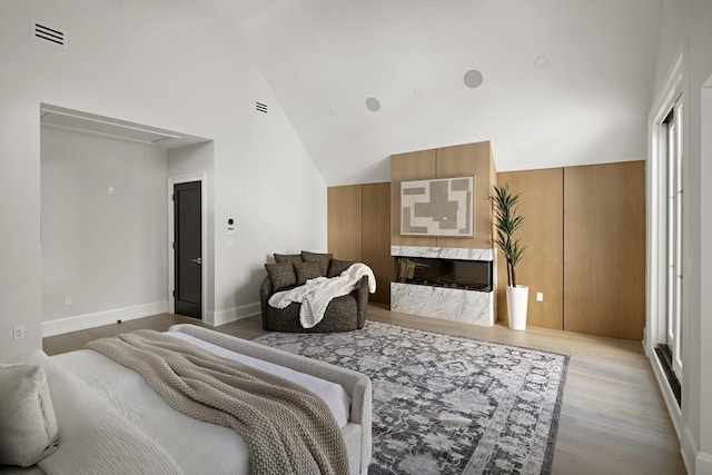 bedroom featuring attic access, wood finished floors, visible vents, and vaulted ceiling