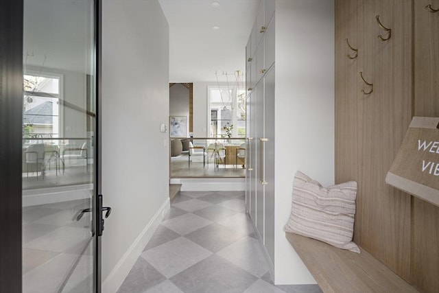 hall with tile patterned floors and a healthy amount of sunlight