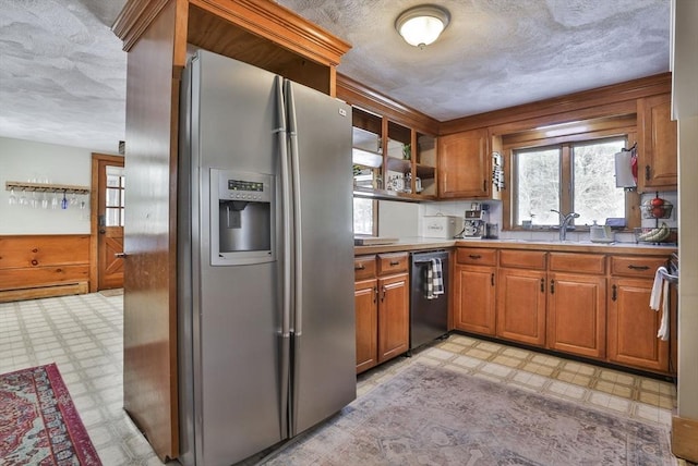 kitchen with stainless steel refrigerator with ice dispenser, black dishwasher, a baseboard heating unit, and sink