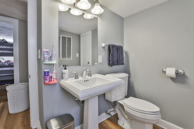 bathroom with toilet and hardwood / wood-style flooring