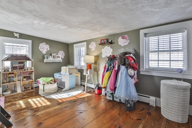 misc room featuring hardwood / wood-style flooring, plenty of natural light, and a baseboard radiator