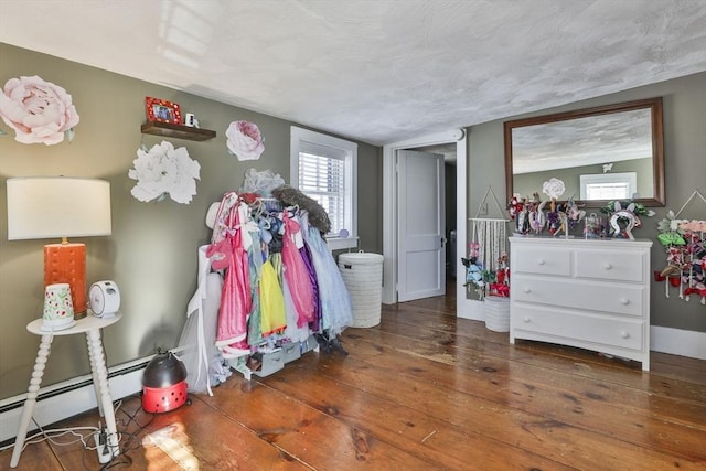 bedroom featuring a textured ceiling, dark hardwood / wood-style floors, and a baseboard radiator