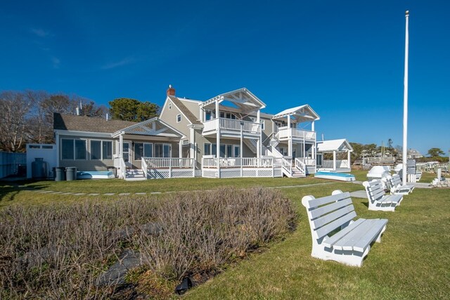 back of house with a yard, a balcony, and a deck