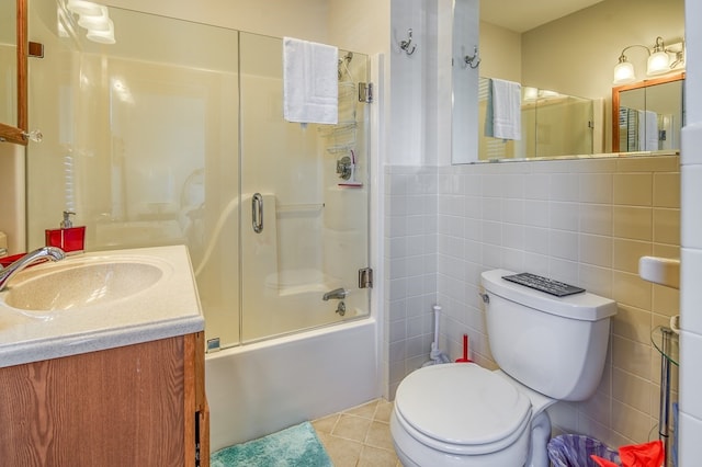 full bathroom with tile walls, toilet, enclosed tub / shower combo, tile flooring, and vanity