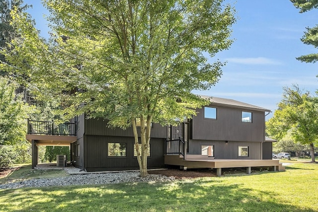 rear view of property featuring a yard, central AC, and a deck