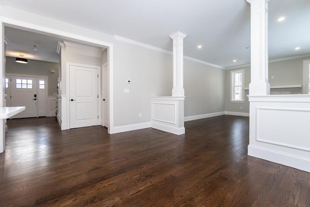 unfurnished living room with dark wood-type flooring, ornamental molding, and ornate columns