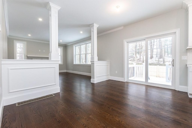 unfurnished living room with crown molding, dark hardwood / wood-style floors, and ornate columns