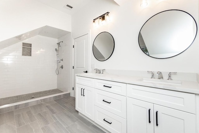 bathroom featuring vanity and tiled shower