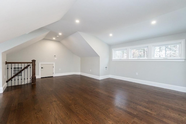 bonus room featuring dark wood-type flooring and vaulted ceiling