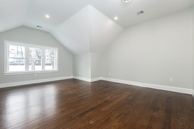 bonus room with dark wood-type flooring and vaulted ceiling