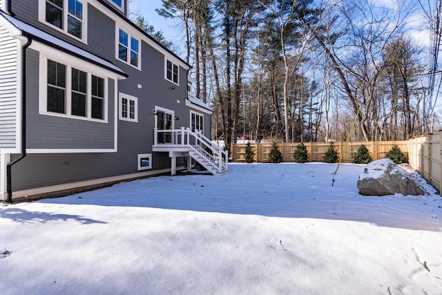 yard covered in snow featuring a deck