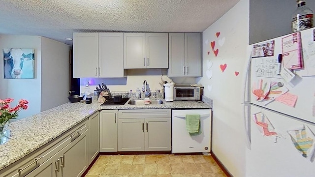 734 Main St, Amherst, MA 01002 - kitchen featuring white appliances, a sink, a textured ceiling, light stone counters, and a peninsula
