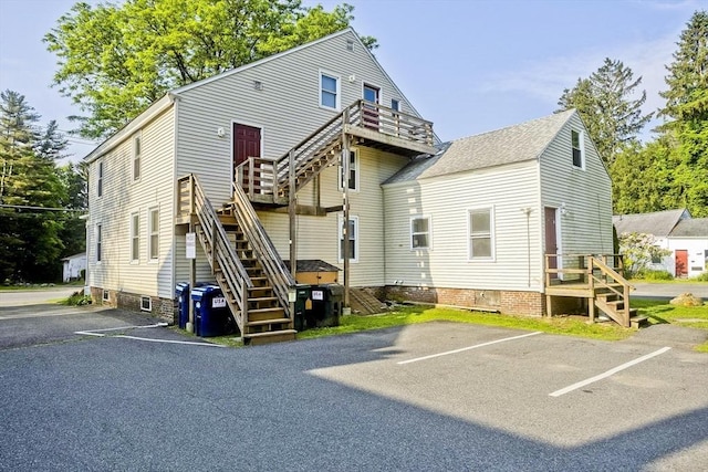 734 Main St, Amherst, MA 01002 - rear view of house featuring stairway, uncovered parking, and a deck