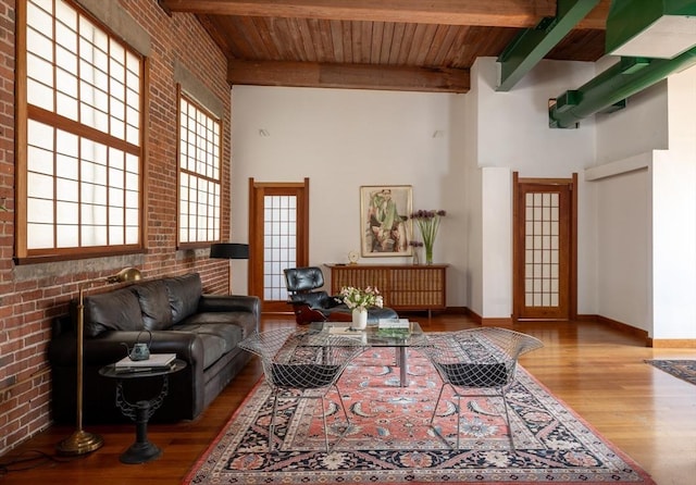 543 Green St, Cambridge, MA 02139 - living area featuring a high ceiling, a wood ceiling with exposed beams, wood finished floors, and brick wall