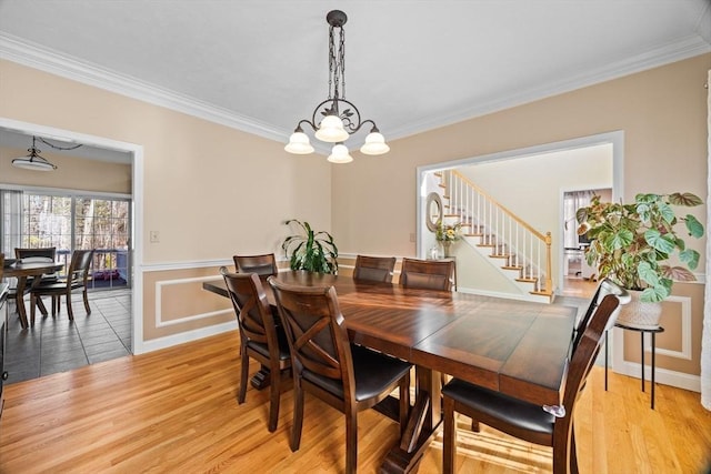 dining area featuring a notable chandelier, crown molding, and light hardwood / wood-style flooring