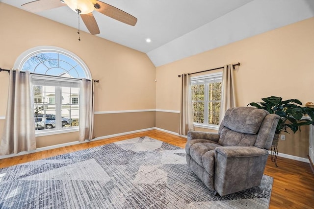 sitting room with hardwood / wood-style flooring, ceiling fan, vaulted ceiling, and a wealth of natural light