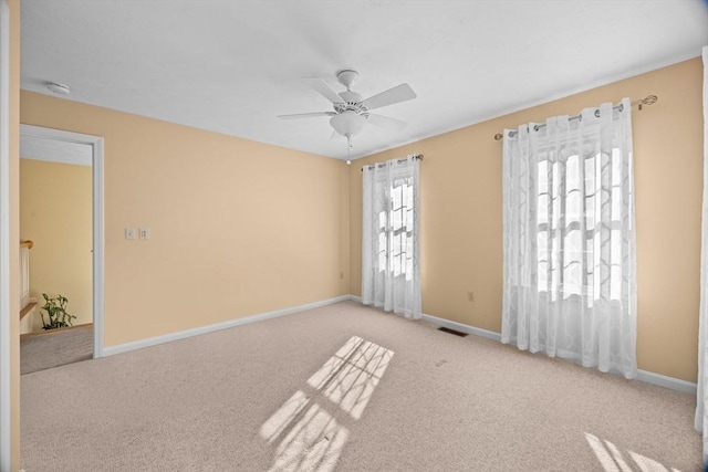 carpeted spare room with ceiling fan