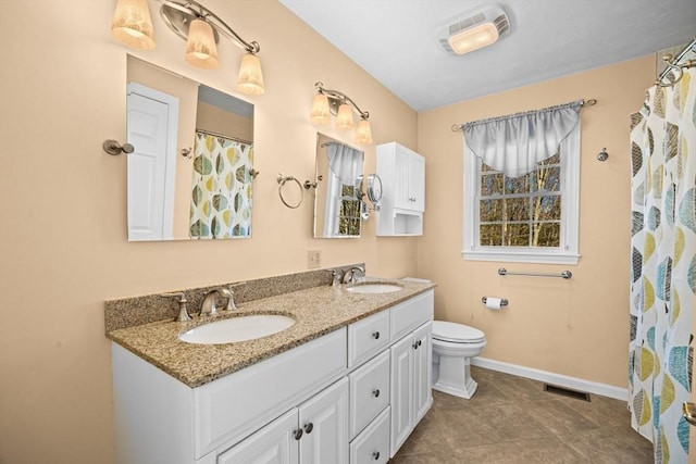 bathroom with vanity, curtained shower, and toilet