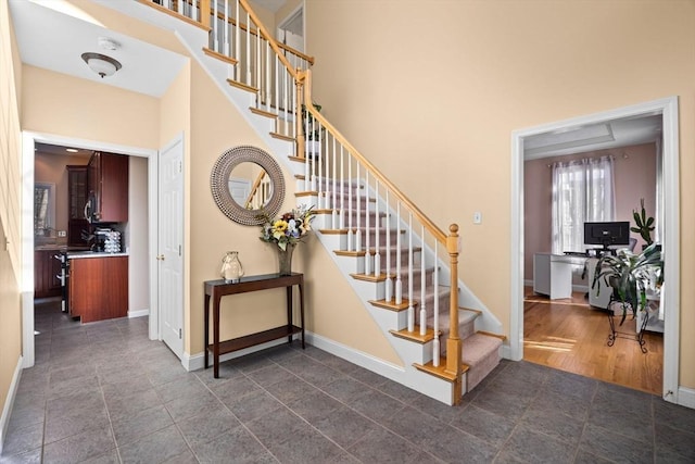 staircase featuring tile patterned floors and a high ceiling