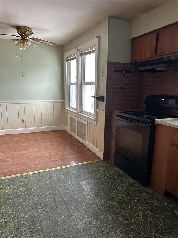 kitchen with black / electric stove, dark hardwood / wood-style floors, and ceiling fan