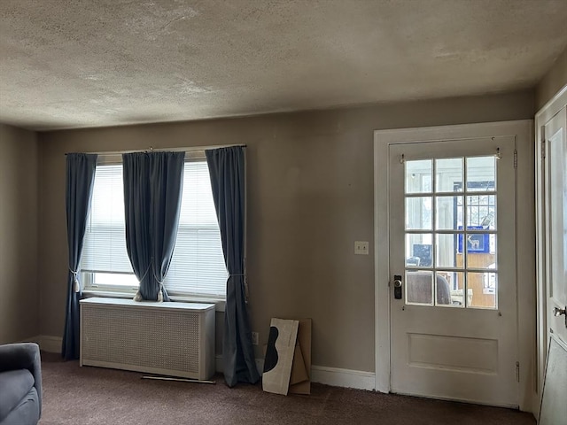 entryway featuring carpet, radiator, and a textured ceiling