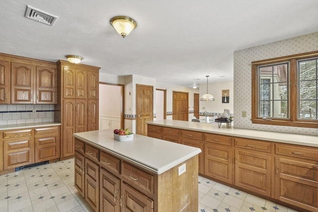 kitchen featuring tasteful backsplash, hanging light fixtures, and a center island