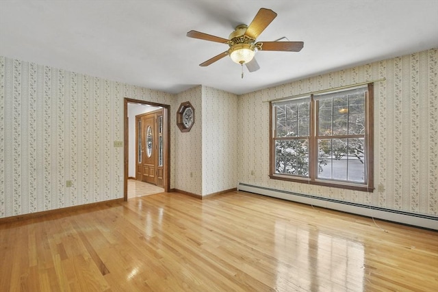 empty room featuring baseboard heating, ceiling fan, and hardwood / wood-style flooring