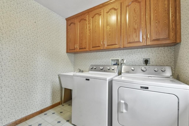 clothes washing area featuring independent washer and dryer and cabinets