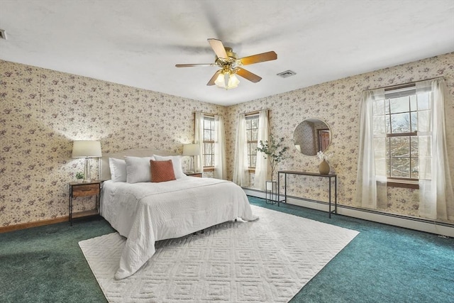 carpeted bedroom featuring baseboard heating, ceiling fan, and multiple windows