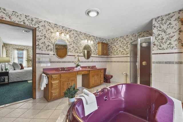 bathroom featuring shower with separate bathtub, tile patterned floors, tile walls, and vanity