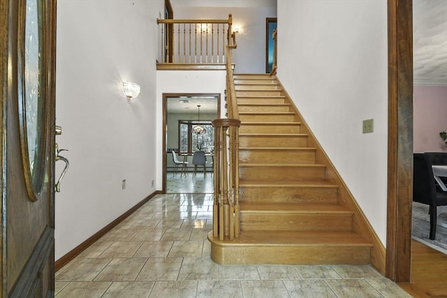 stairs with a high ceiling and tile patterned flooring