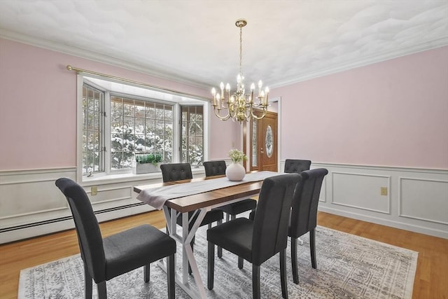 dining area featuring hardwood / wood-style flooring, ornamental molding, and an inviting chandelier