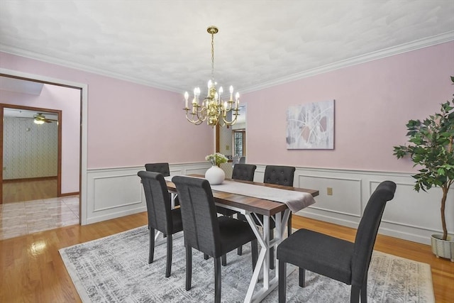 dining area featuring ornamental molding, light hardwood / wood-style flooring, and ceiling fan with notable chandelier