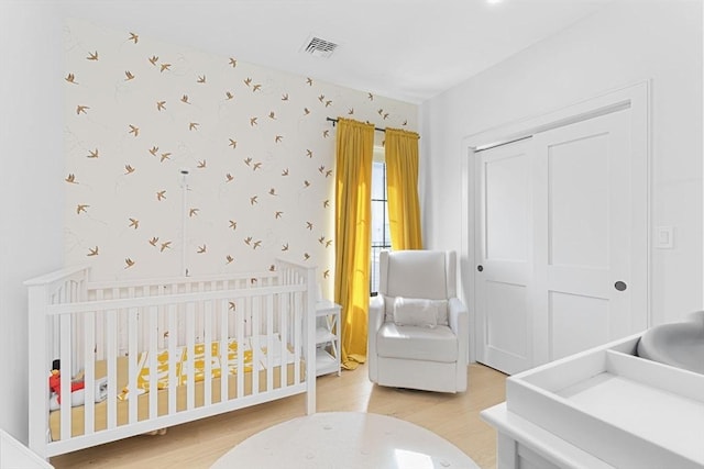 4 Payne St One, Unit One, Boston, MA 02122 - bedroom with light wood finished floors, wallpapered walls, a closet, and a nursery area