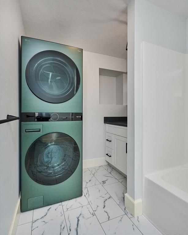 116 Holyoke St, Easthampton, MA 01027 - laundry area featuring estacked washer and dryer and light marble finish floors