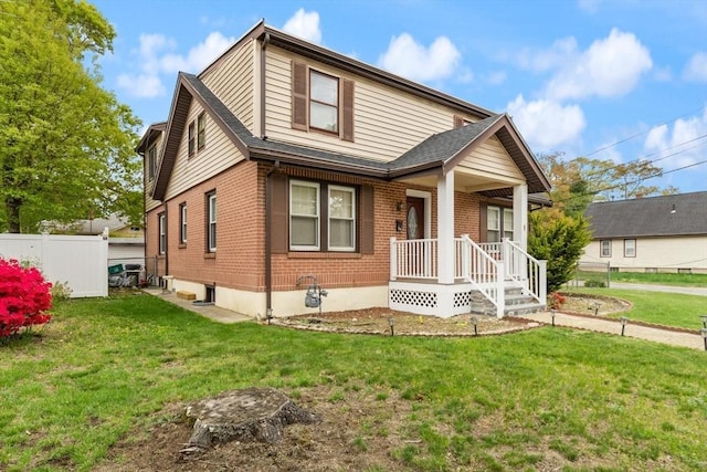 view of front of home featuring brick siding, covered porch, and a shingled roof
