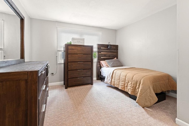 bedroom with light carpet and baseboards
