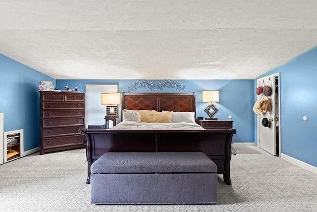 carpeted bedroom featuring a textured ceiling and baseboards