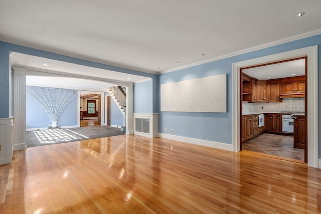 unfurnished living room featuring light wood-type flooring and crown molding