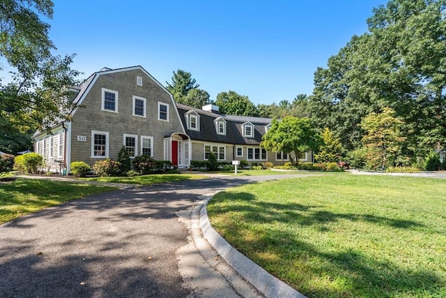 view of front of property featuring a front lawn and a gambrel roof