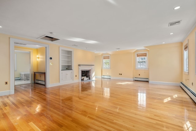 unfurnished living room featuring built in shelves, a baseboard radiator, and light wood-type flooring